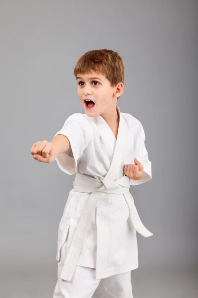 Karate-Junge im weißen Kimono kämpft — Stockfoto