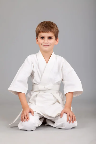 Karate-Junge im weißen Kimono kämpft — Stockfoto