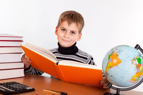 Söt skolpojke läser en bok — Stockfoto