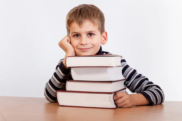 Schooljongen en een hoop van boeken — Stockfoto