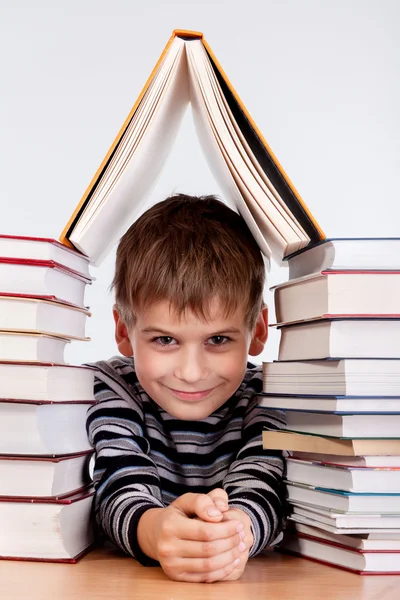 Schooljongen en een hoop van boeken — Stockfoto