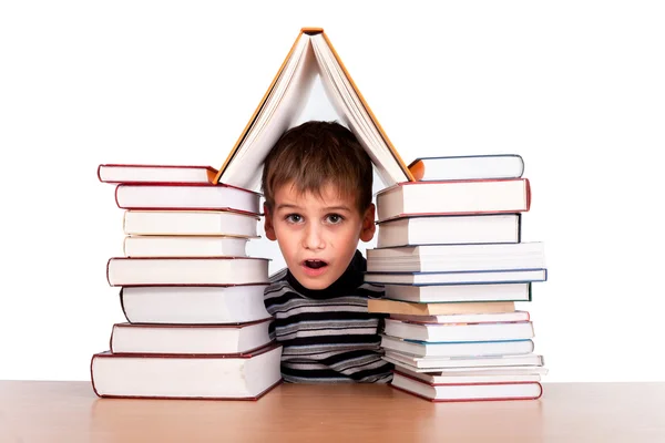 Schooljongen en een hoop van boeken — Stockfoto