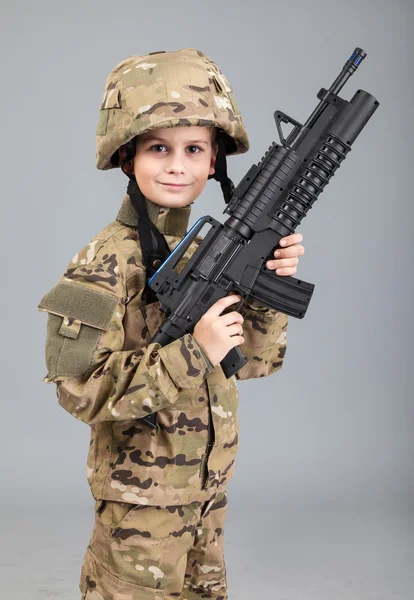 Мальчик, одетый как солдат с винтовкой — стоковое фото