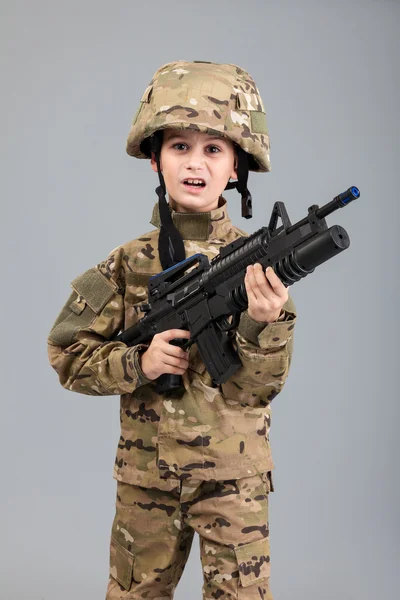 Ung pojke klädd som en soldat med gevär — Stockfoto