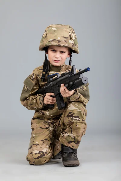 Junge wie ein Soldat mit Gewehr gekleidet — Stockfoto