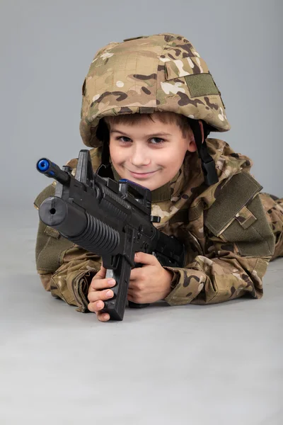 Junge wie ein Soldat mit Gewehr gekleidet — Stockfoto