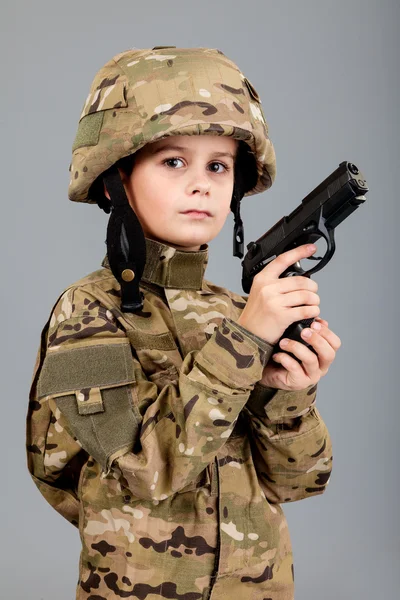 Young boy dressed like a soldier with a gun — Stock Photo, Image