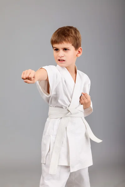 Karate chlapec v bílém kimonu bojuje — Stock fotografie