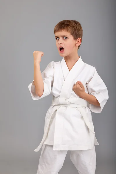 Karate-Junge im weißen Kimono kämpft — Stockfoto