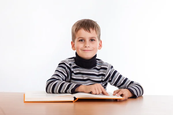 Cute schoolboy is reading a book — Stock Photo, Image