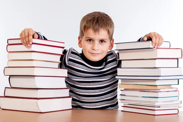 Schooljongen en een hoop van boeken — Stockfoto