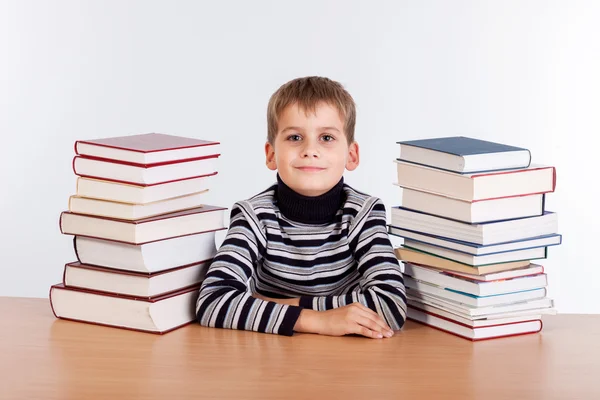 Schooljongen en een hoop van boeken — Stockfoto