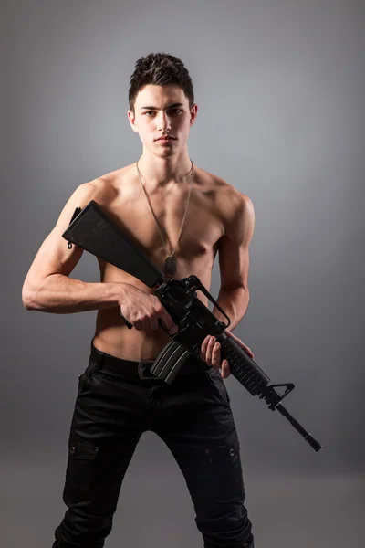 Bare-chested soldier holding a rifle — Stock Photo, Image