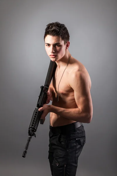 Bare-chested soldier holding a rifle — Stock Photo, Image