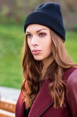 Bankta oturan genç bir kadın.