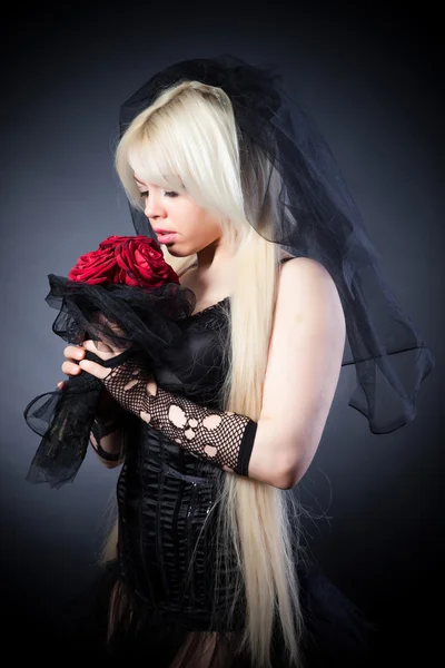 Black widow in grief with flowers — Stock Photo, Image