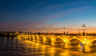 Panorama of Pont de pierre, old stony bridge in Bordeaux in a beautiful summer night, France clipart