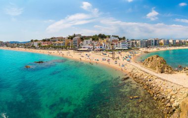 Turistler, İspanya 'nın güzel bir yaz gününde Costa Brava' nın Blanes plajında eğleniyorlar.