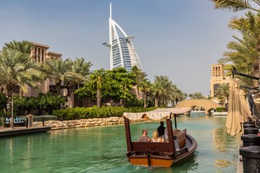 DUBAI, BİRLİK ARAB EMIRATES - 31 HAZİRAN 2020: Güneşli bir Dubai gününde Madinat Jumeirah lüks otelinden Burj Al-Arap oteline bakın