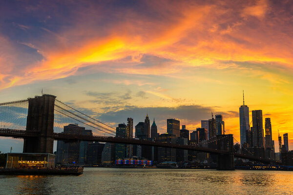 Sunset view of Brooklyn Bridge and panoramic view of downtown Manhattan in New York City, USA