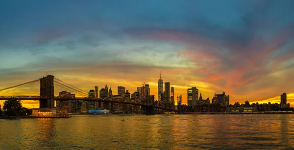 Brooklyn Köprüsü 'nün Sunset Manzarası ve New York City, ABD' deki Manhattan şehir merkezinin panoramik manzarası.