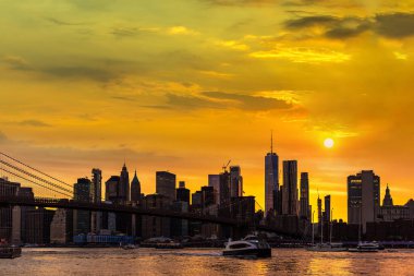 Brooklyn Köprüsü 'nün günbatımı ve New York City, ABD' deki Manhattan şehir merkezinin panoramik manzarası.