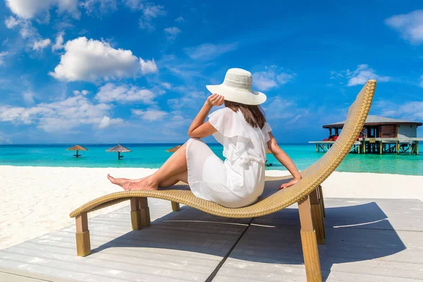 Güneşli bir yaz gününde lüks bir tropik plajda güneşlenen güzel bir kadın.