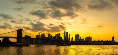 Brooklyn Köprüsü 'nün Sunset Manzarası ve New York City, ABD' deki Manhattan şehir merkezinin panoramik manzarası.