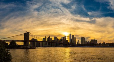 Brooklyn Köprüsü 'nün Sunset Manzarası ve New York City, ABD' deki Manhattan şehir merkezinin panoramik manzarası.