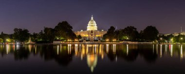 Panorama of  The United States Capitol building and Capitol Reflecting Pool at sunset at night in Washington DC, USA