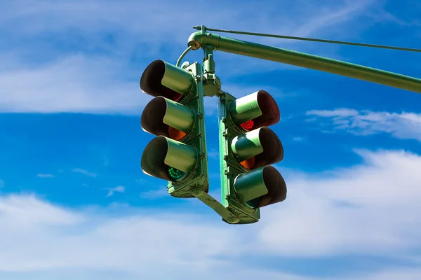 Green Traffic light on green against clear blue sky in New York City, NY, USA