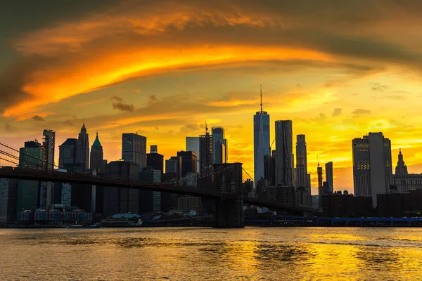 Brooklyn Köprüsü 'nün günbatımı ve New York City, ABD' deki Manhattan şehir merkezinin panoramik manzarası.