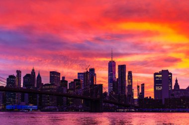 Brooklyn Köprüsü 'nün günbatımı ve New York City, ABD' deki Manhattan şehir merkezinin panoramik manzarası.