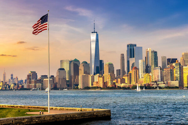 Panoramic view of Manhattan cityscape and USA flag in New York City at sunset, NY, USA
