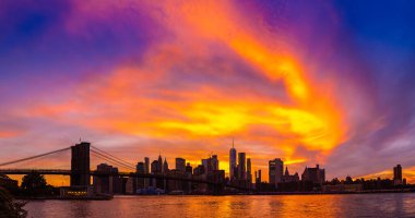 Brooklyn Köprüsü 'nün Sunset Manzarası ve New York City, ABD' deki Manhattan şehir merkezinin panoramik manzarası.