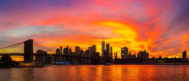 Brooklyn Köprüsü 'nün Sunset Manzarası ve New York City, ABD' deki Manhattan şehir merkezinin panoramik manzarası.