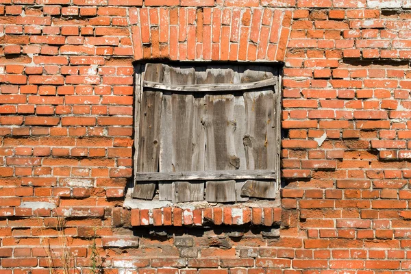 Блокированное окно на фоне стены из красного кирпича . — стоковое фото