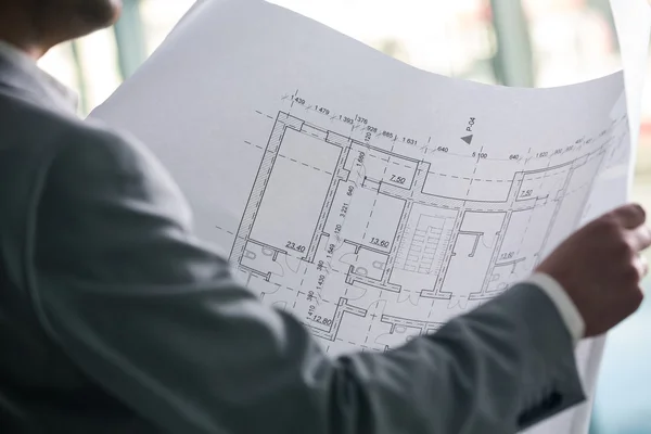 Архитектурный план в руках архитектора — стоковое фото