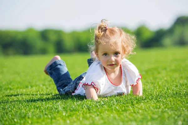 Bir çim üzerinde küçük mutlu kız — Stok fotoğraf
