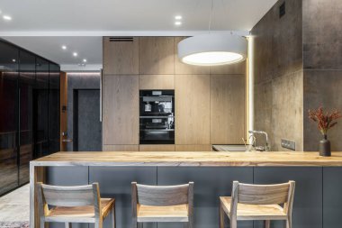 Modern minimalist kithen iç döşeme, doğal ahşap kaplama mobilyalar, stüdyo dairelerde dahili ekipmanlar. İç tasarım kavramı 