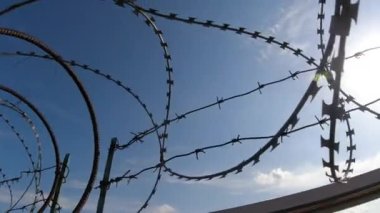 Yasak bölgeyi koruyan dikenli teller. Derin mavi gökyüzü üzerinde yavaş çekim görünümü