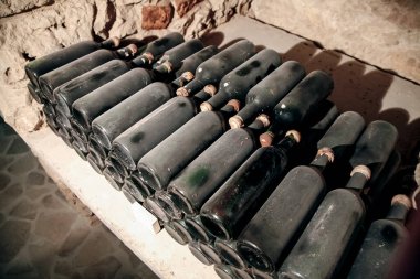 Şarap mahzeninde tozla kaplı şarap şişeleri. Avrupa 'da şarap üretimi endüstrisi