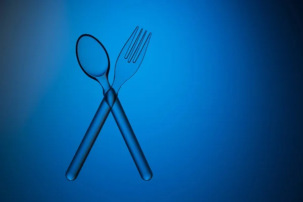 Cuchara Transparente Plástico Tenedor Cruzados Sobre Fondo Azul Captura Estudio — Foto de Stock