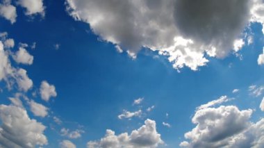 Beyaz tüylü kümülüs bulutlarının bir yaz günü güneşli mavi gökyüzünde hareket ettiğini gösteren hızlandırılmış video. Yaz meteorolojisi