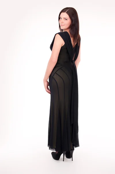 Mooie jonge vrouw die een sexy zwarte avond jurk dragen — Stockfoto