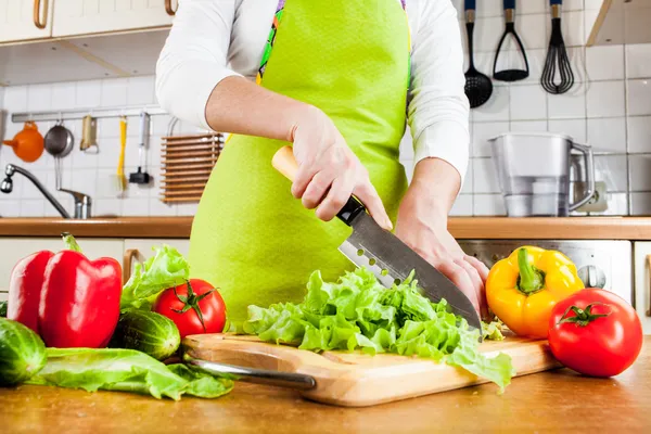 Las manos de mujer cortando verduras — Foto de Stock