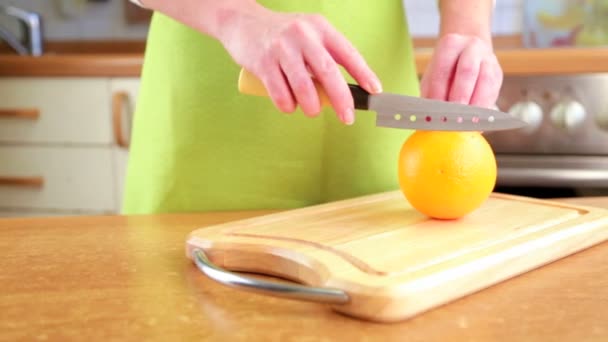 Les mains de la femme coupant orange — Video