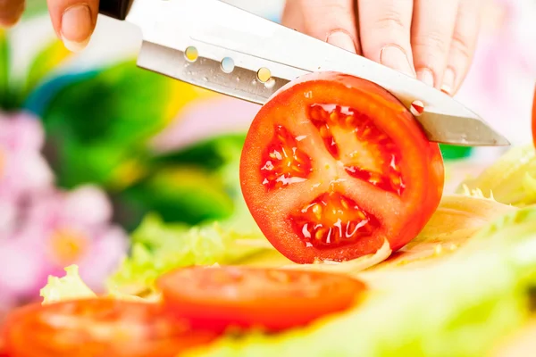 Mãos de mulher cortando tomate — Fotografia de Stock