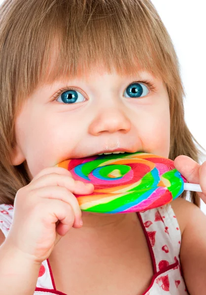 Baby girl eating a sticky lollipop — Stock Photo, Image
