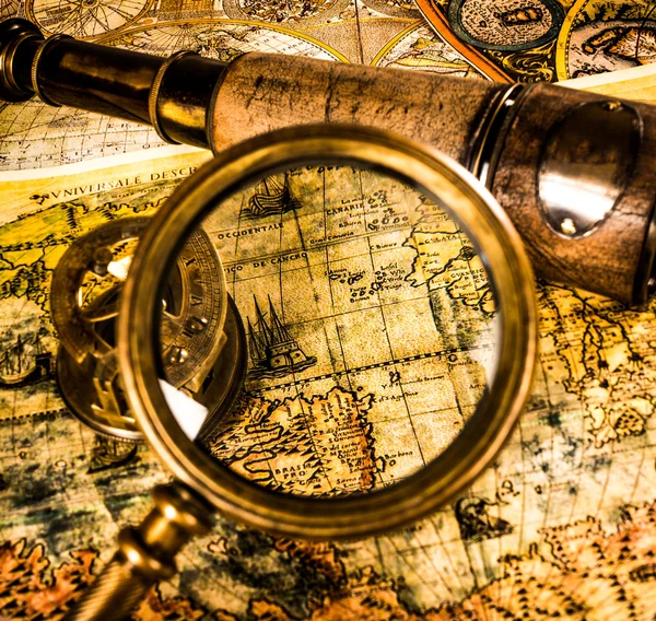 Vintage magnifying glass lies on an ancient world map — Stock Photo, Image